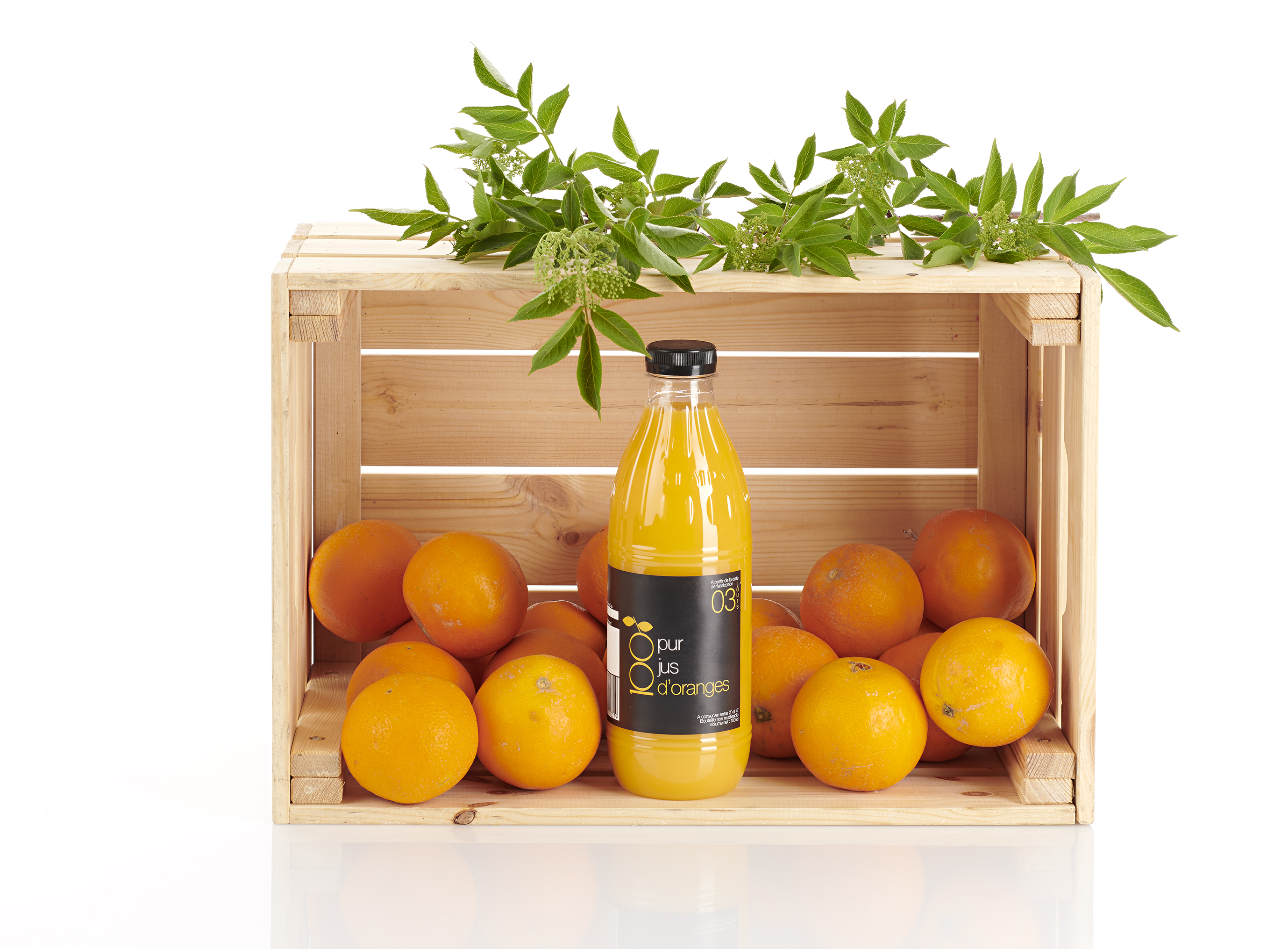 Caisse d’oranges accompagnée d’une bouteille de jus frais