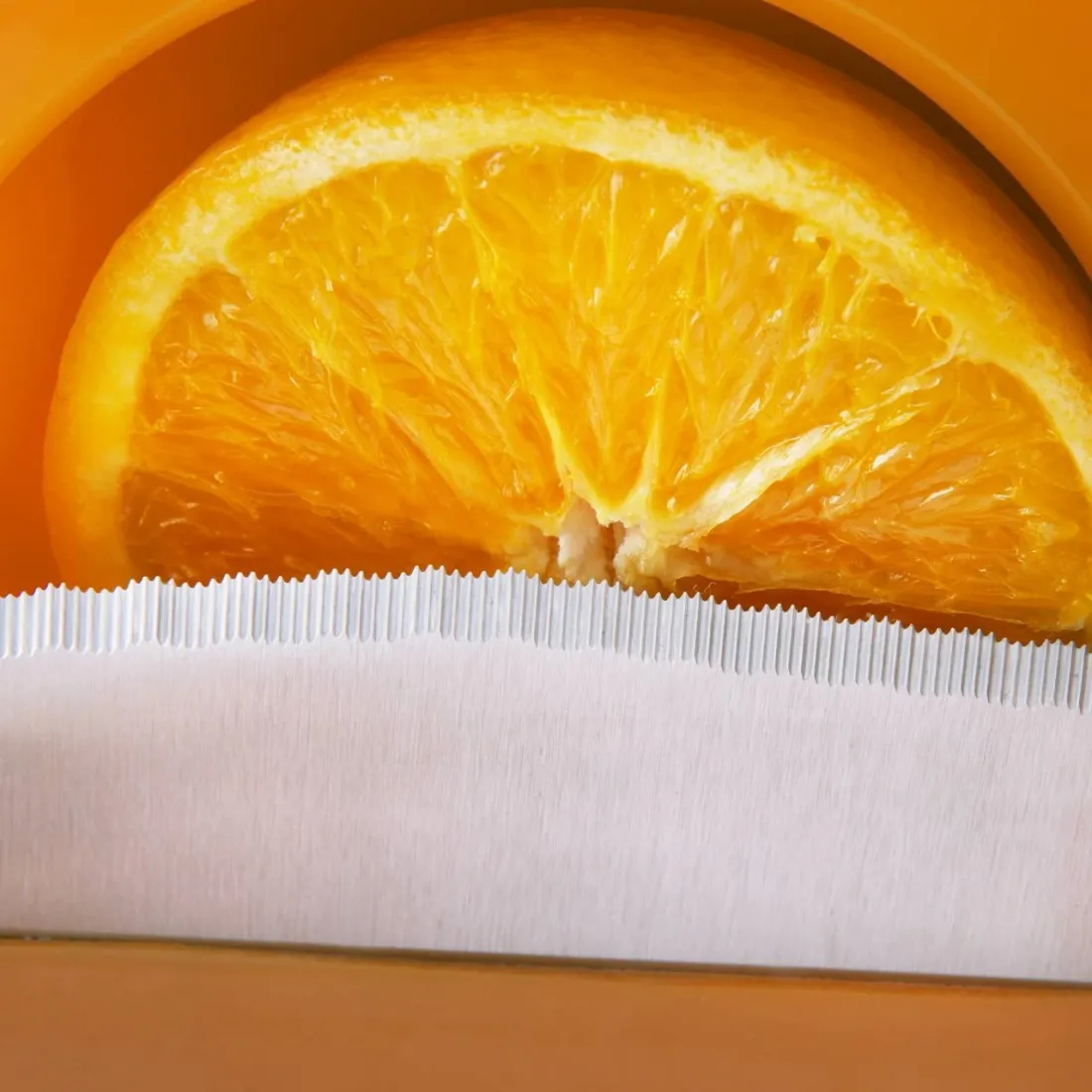 Gros plan d’une lame tranchant une demi-orange dans l’OL 41